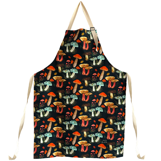 A cotton apron with an adjustable neck and waist, featuring hand painted illustrations of various mushrooms in vibrant colours.
