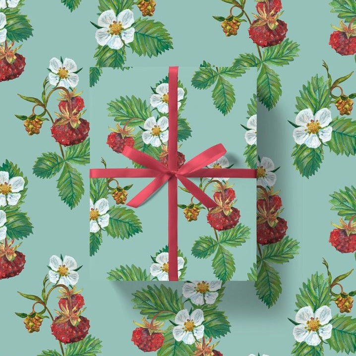 Gift wrap with red wild strawberries and foliage shown with red ribbon on a background of the same pattern