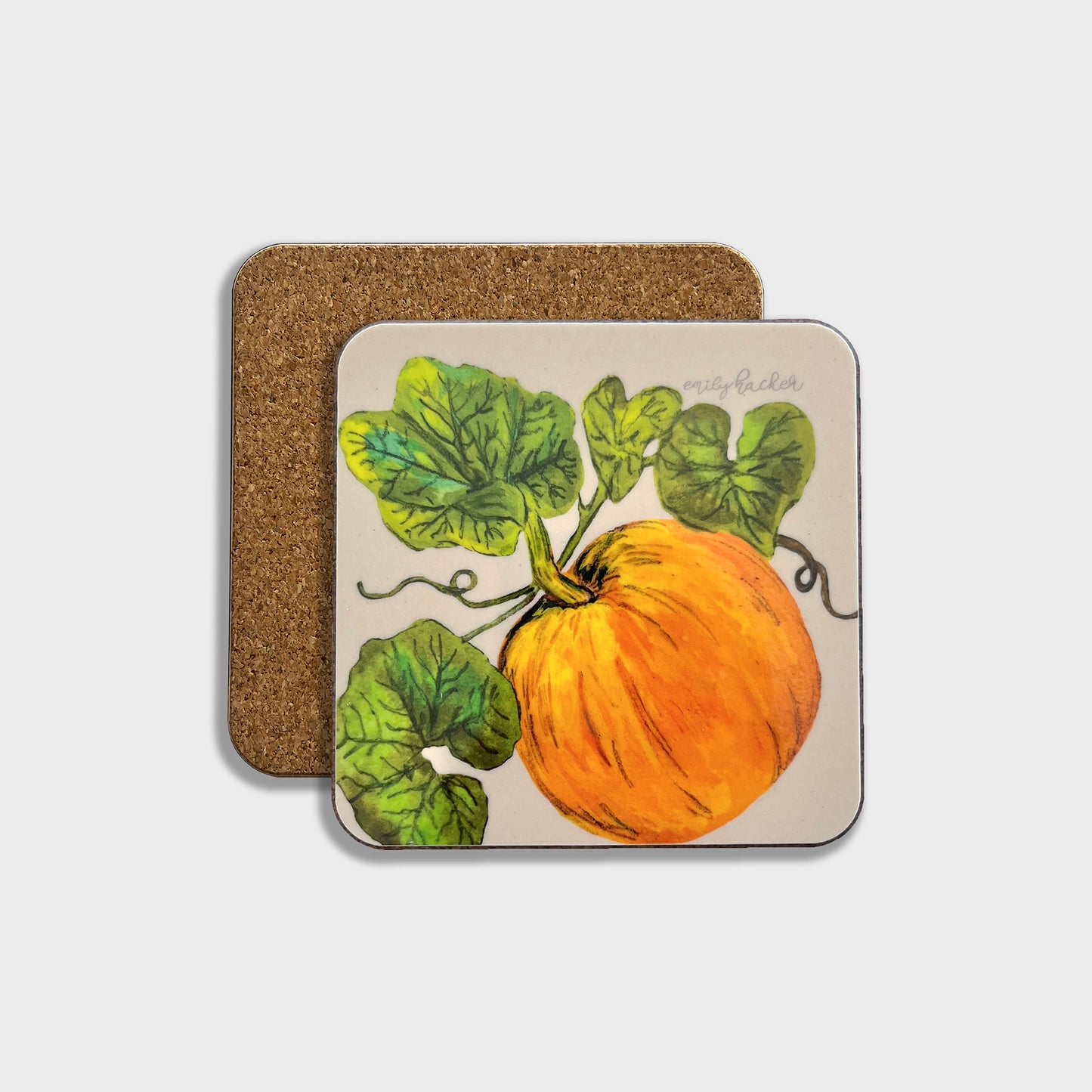 An orange pumpkin coaster with a hand-painted illustration of a pumpkin and foliage on a cork backing.