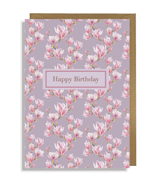 Magnolia flower buds with on a lilac background and the text 'Happy Birthday' arranged in a pattern.