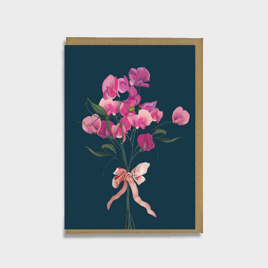 Greeting card with pink flowers and a bow on a dark blue background