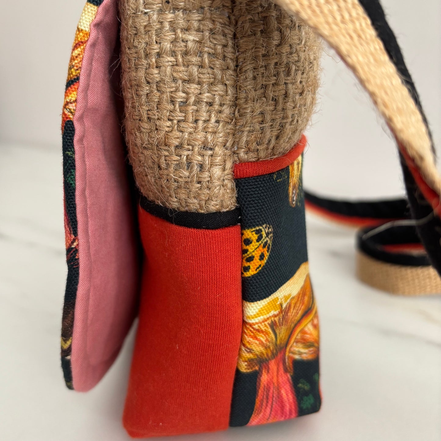 Handbag with mushroom pattern side view showing burnt orange colourway on a marble surface