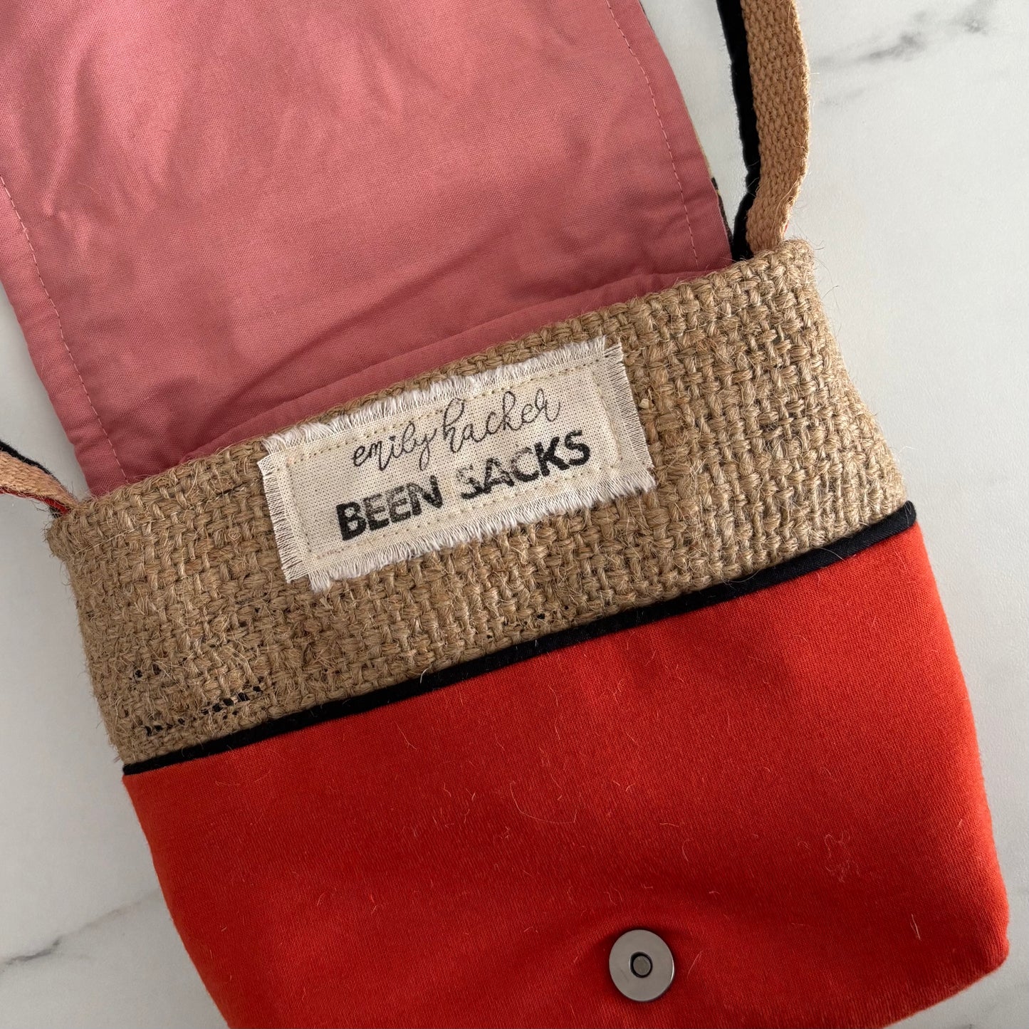 Red bag with a 'been sacks' label on a marble surface