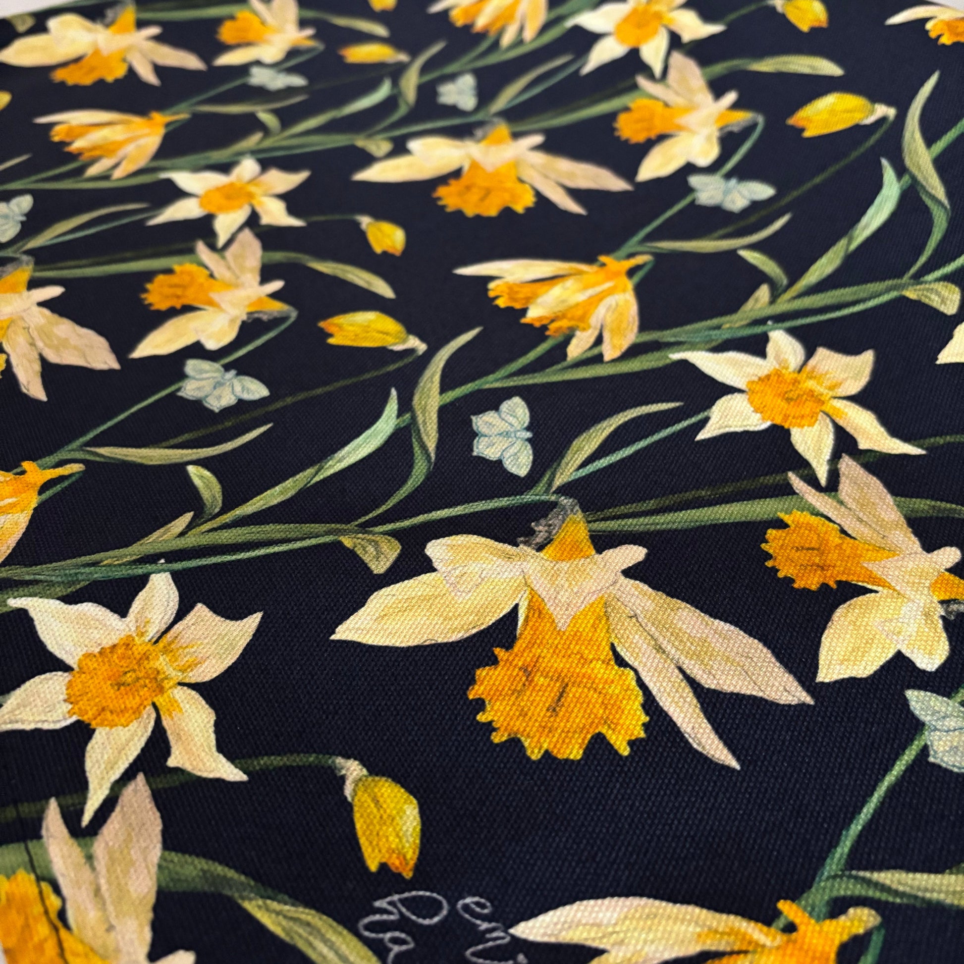 Floral wild daffodil pattern tea towel with yellow flowers on a dark background