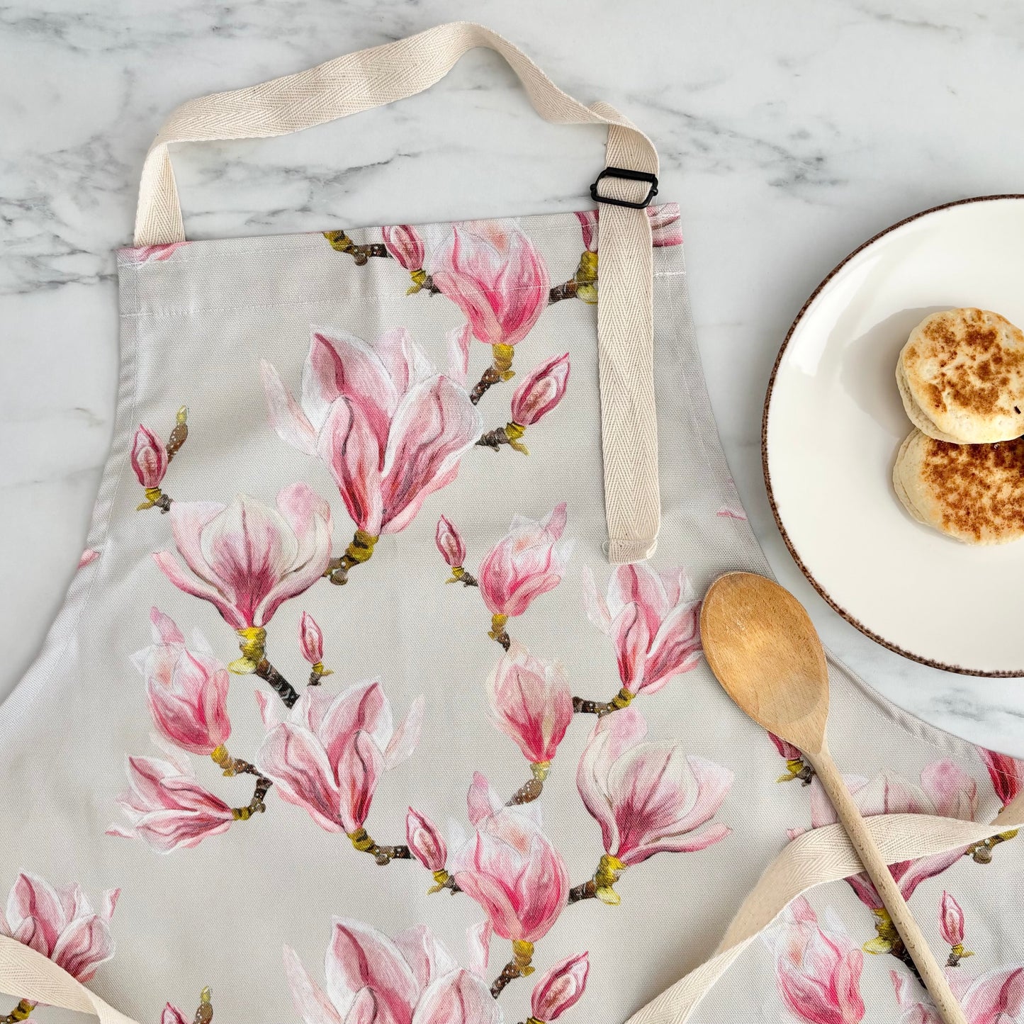 Adult floral apron featuring hand painted pink magnolia flowers on marble background