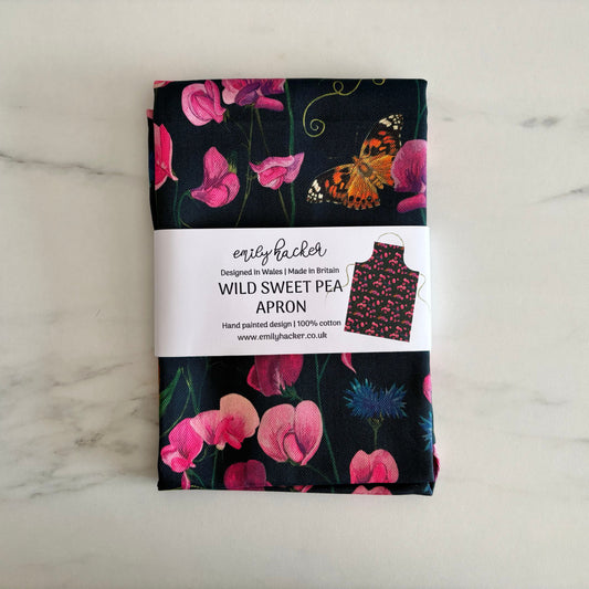 Floral everlasting sweet pea apron packaging with a paper bellyband on a marble surface