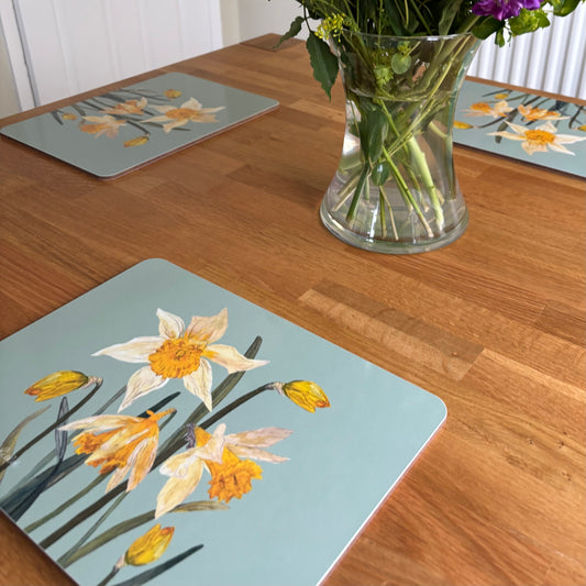 Daffodil placemats with duckegg blue background next to flowers on a wooden table