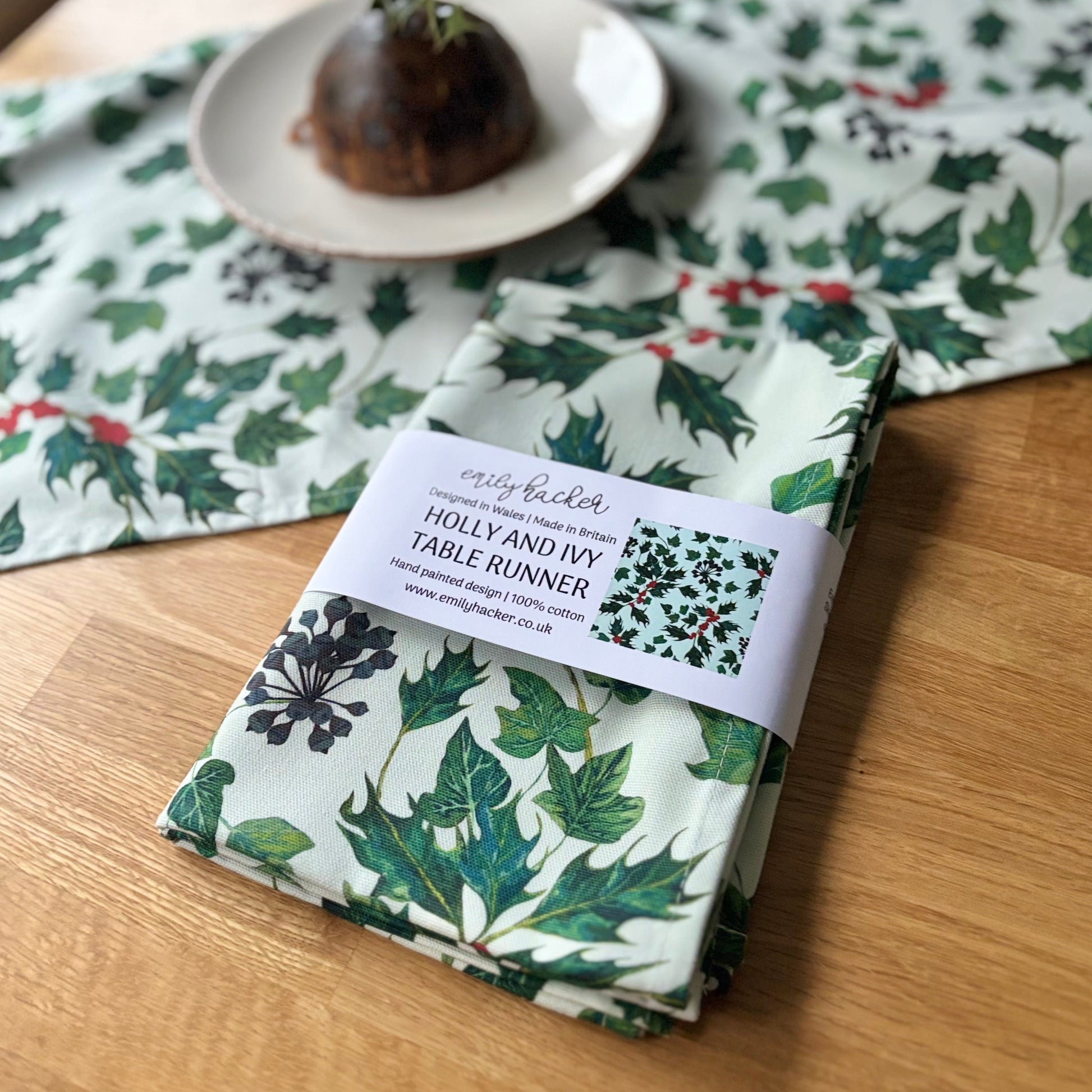 Folded holly and ivy table runner with a label on a wooden surface