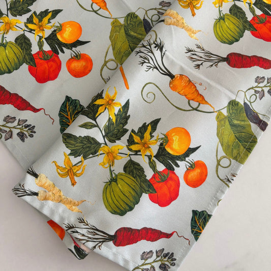 Fabric with colourful heritage vegetable pattern on a light blue grey background