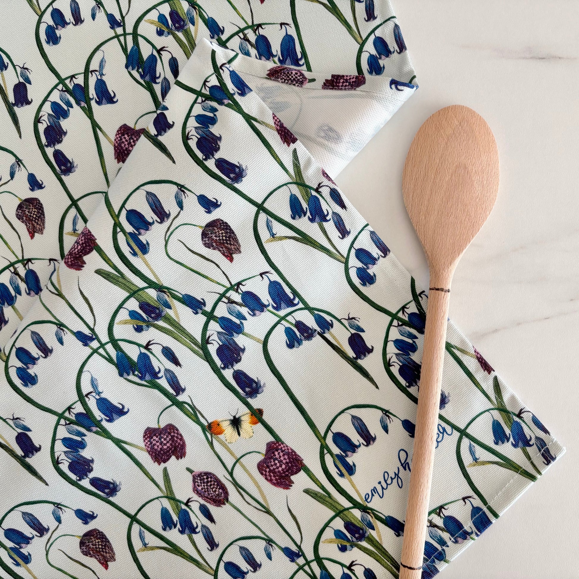 Pure cotton tea towel with hand illustrated bluebell and orange tip butterfly design made in the uk