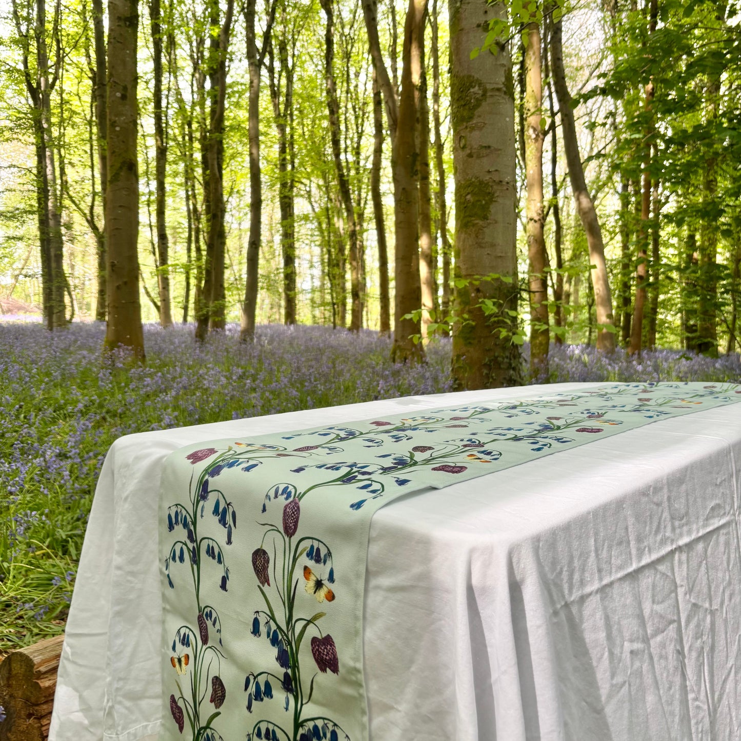 Tablecloth with floral bluebell and snake head fritillary design in a forest setting
