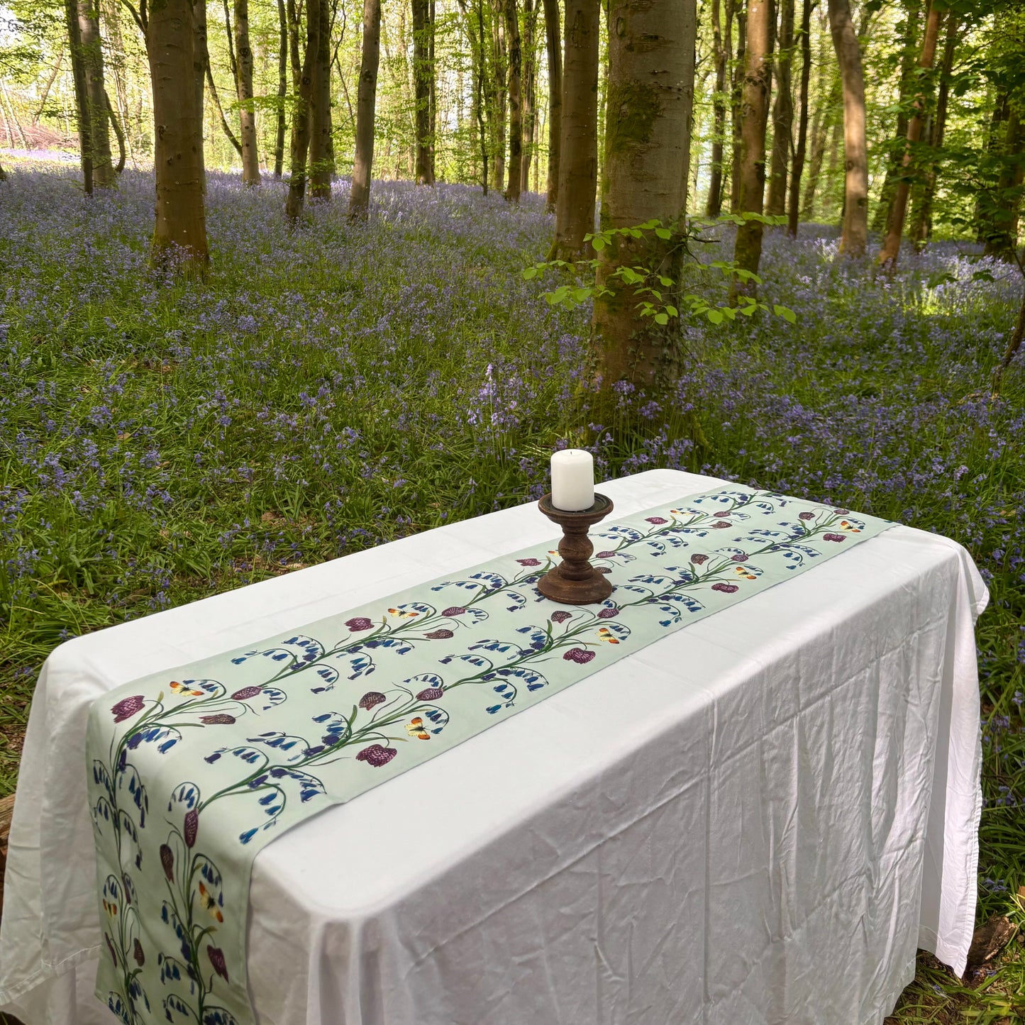 Tablecloth with hand painted floral bluebell pattern in a forest setting