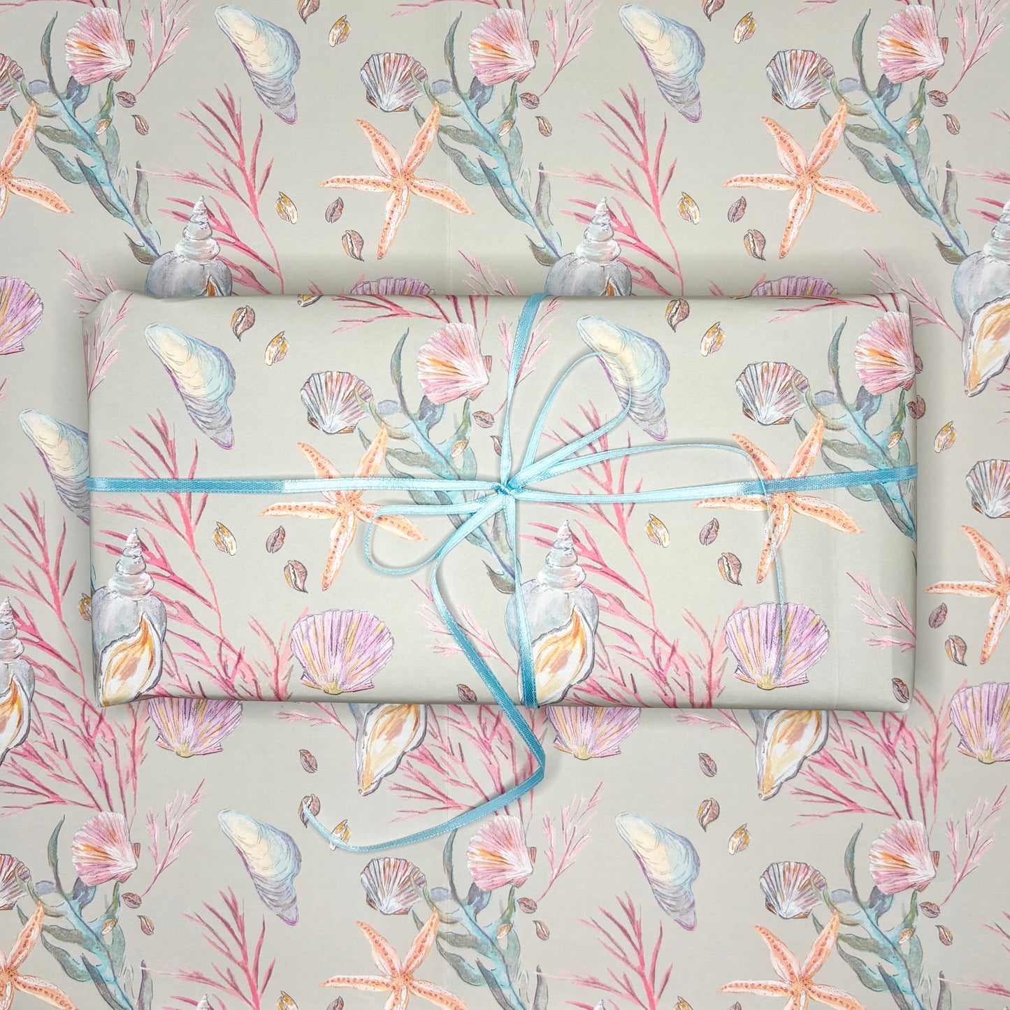 Under the sea themed wrapping paper with a seashell and starfish pattern on a moss green background