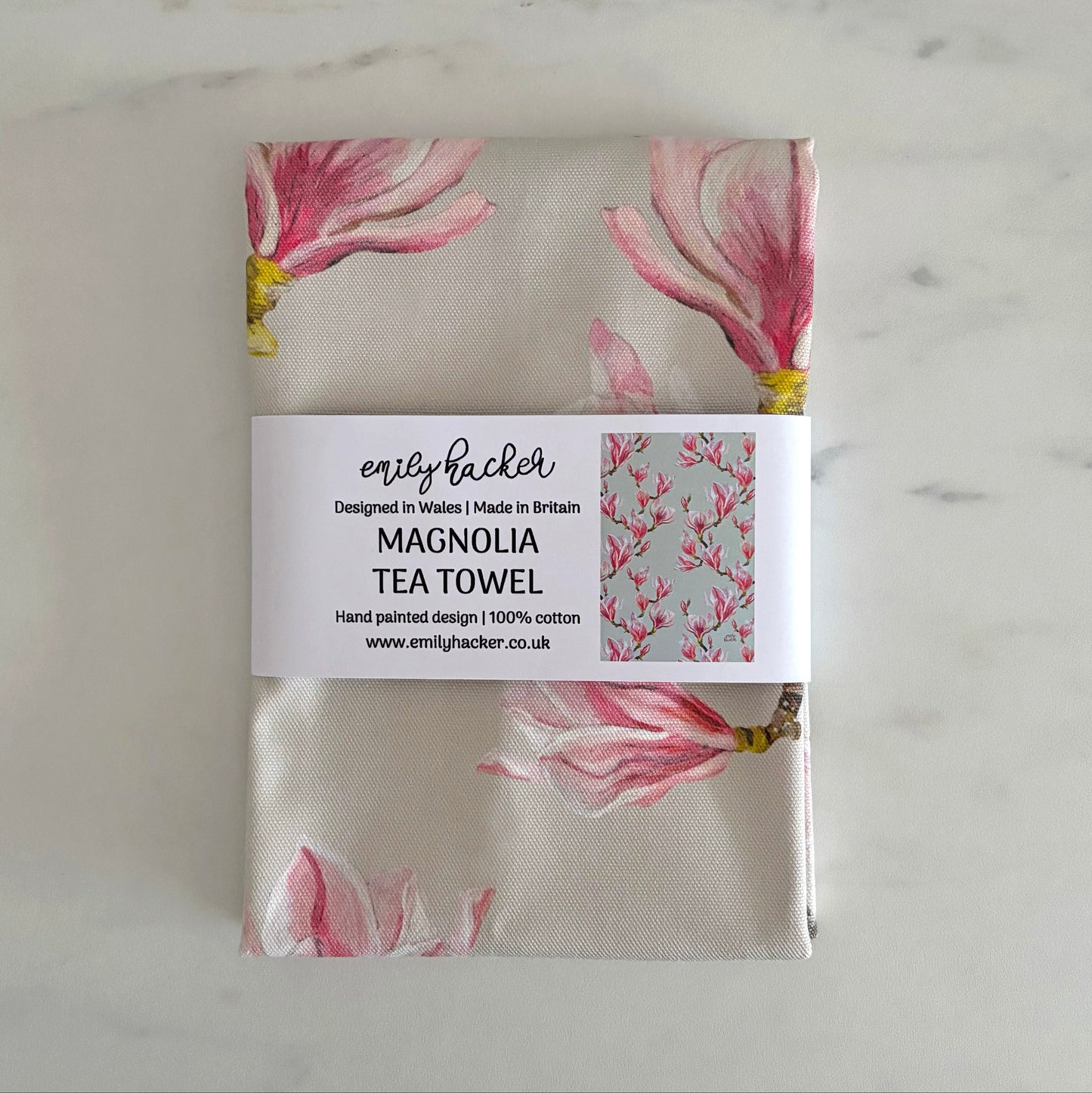 Elegant pink magnolia pure cotton tea towel packaged in a paper bellyband
