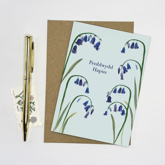 Welsh language Greeting card with whimsical native bluebell design and pen on a white background