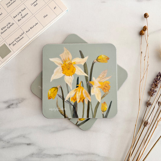 Hand illustrated Coaster with daffodil design on a marble surface with dried plants.