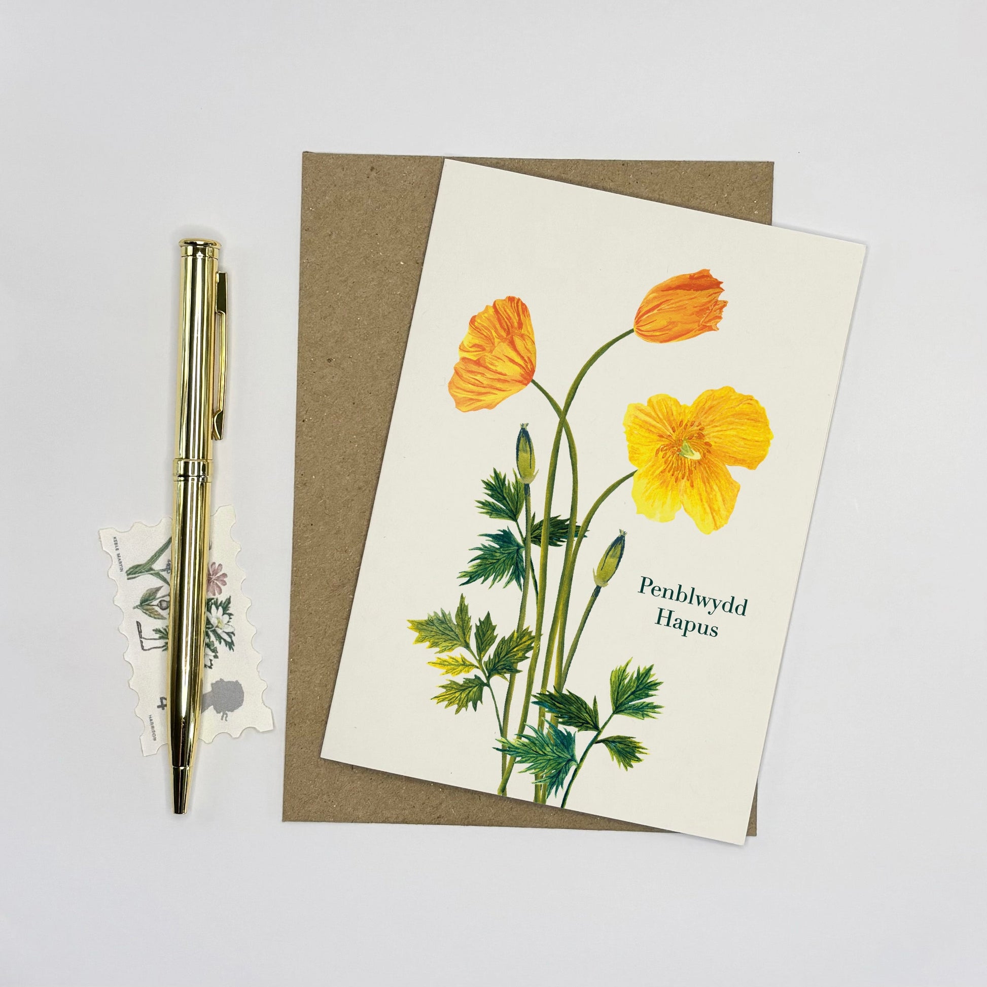 Welsh poppy penblwydd hapus card with yellow british wildflowers and text on a white background
