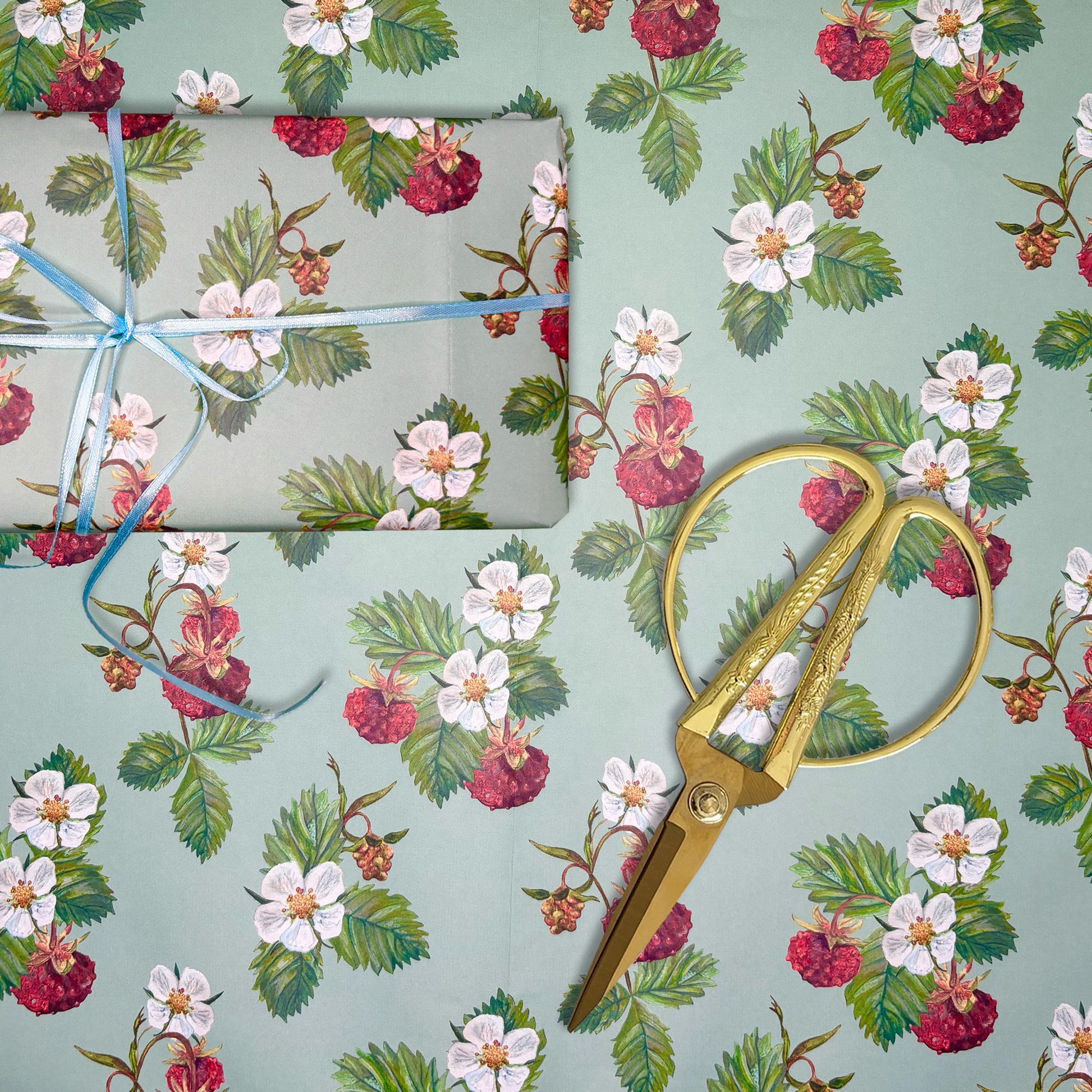 Wild Strawberry illustrated paper with a roll of tape and gold scissors on a matching background