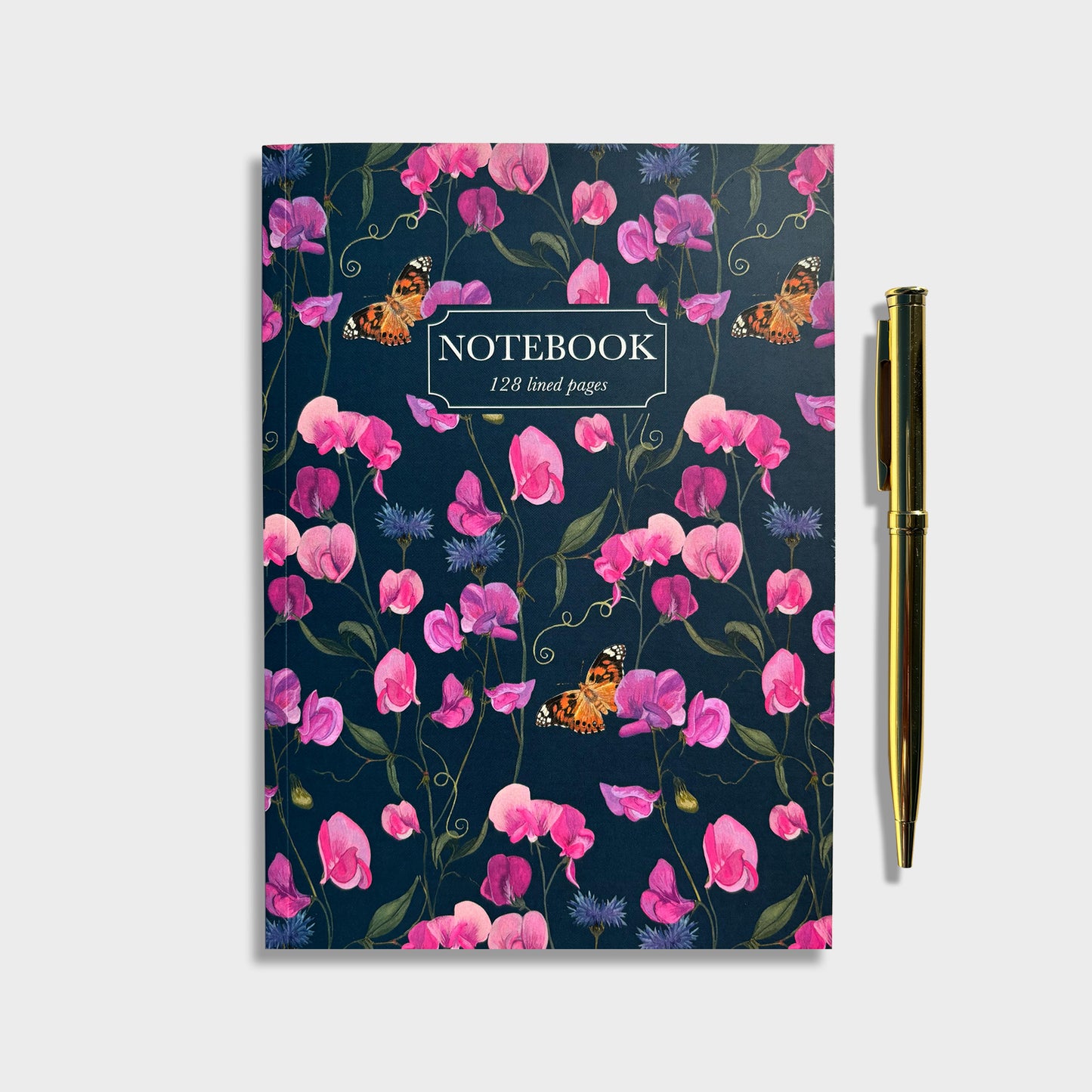 Floral wildflower notebook with dark pink sweet pea flowers and painted lady butterflies on a dark blue background, accompanied by a gold pen.