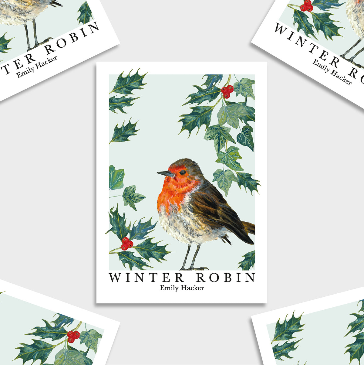A print featuring a winter robin illustration with holly leaves and red berries, shown on a light blue background with several angled copies of the same card around it. The print reads 'WINTER ROBIN' and 'Emily Hacker'.